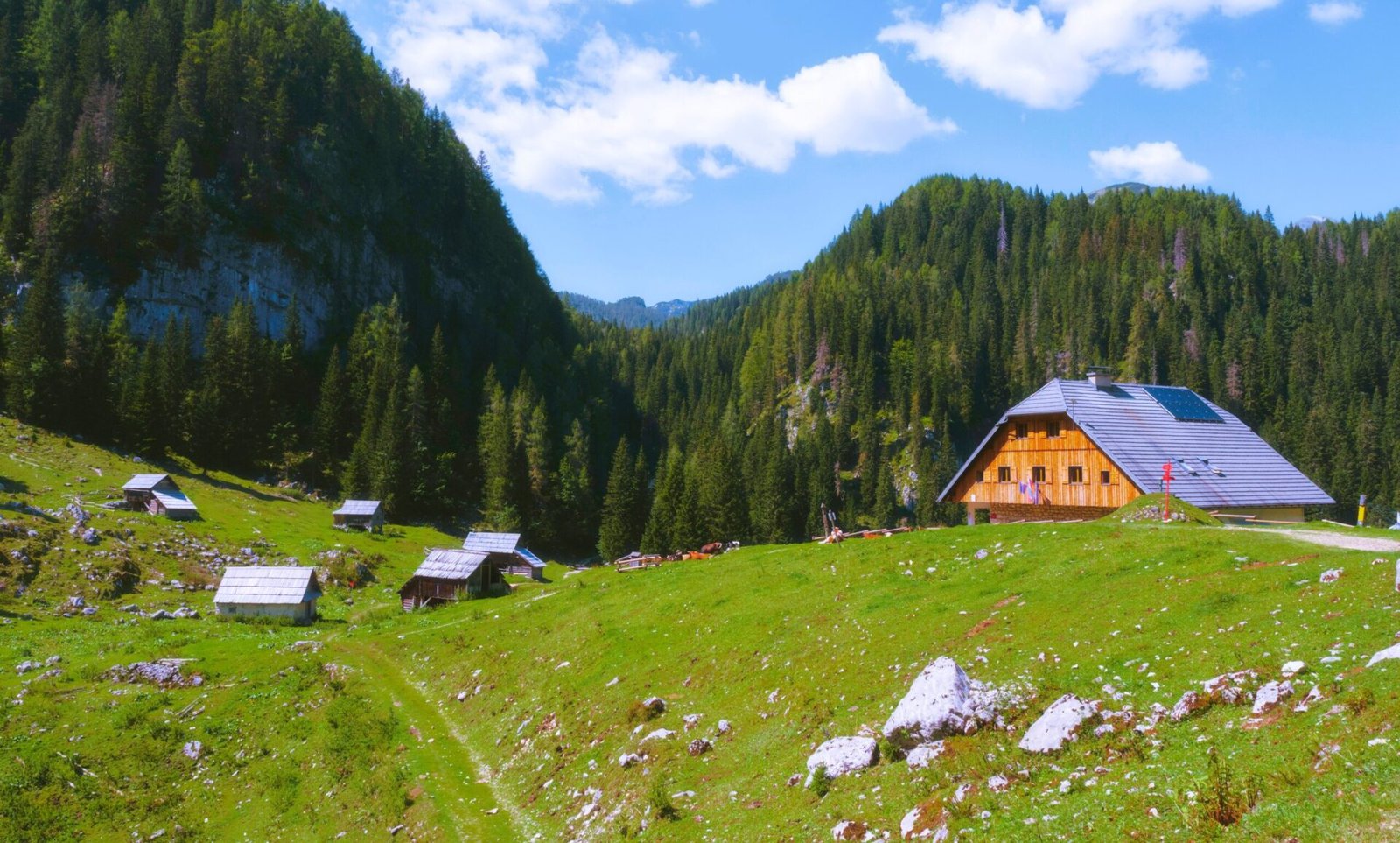 Koča na Planini pri Jezeru is a charming mountain hut located in the heart of the Julian Alps in Slovenia, at an altitude of 1,453 meters. Situated on a scenic alpine meadow near a small lake